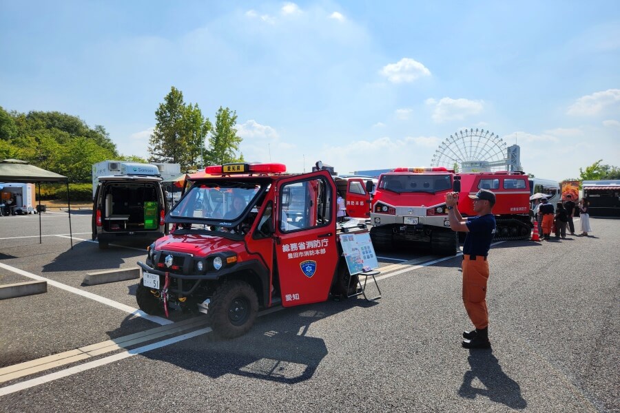 消防車に乗った子どもの写真を撮影する消防隊員