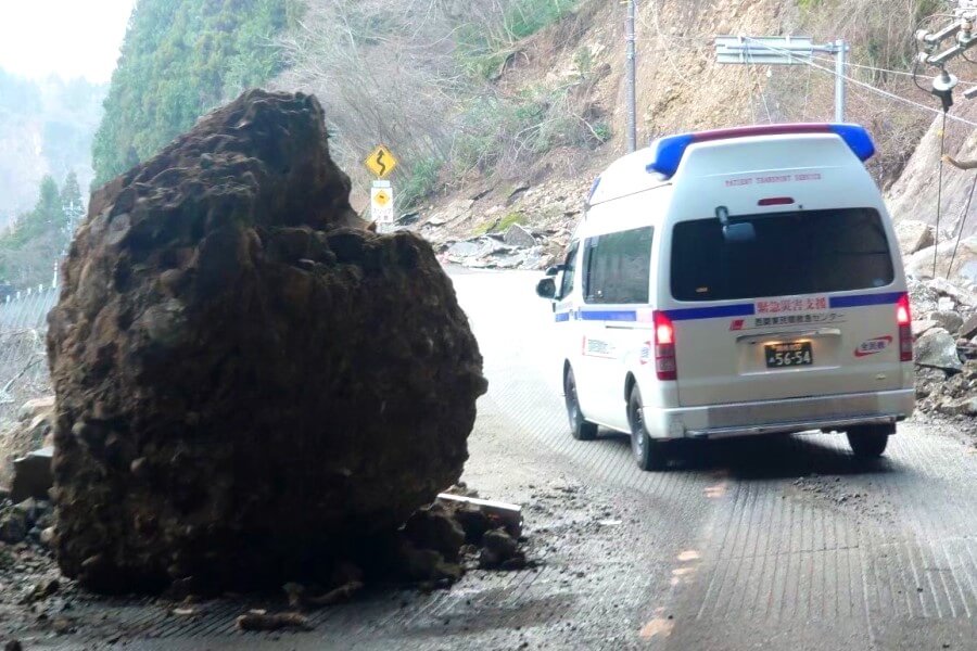 落石をよけて通行する民間救急車